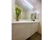 Bathroom vanity with white cabinets, a large mirror, and modern light fixtures at 2132 Fred Brown Dr, Las Vegas, NV 89106