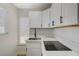 White kitchen with black appliances and marble countertops at 501 Alexander Ave, Las Vegas, NV 89106