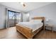 Bedroom with wooden bedframe, sliding glass door to balcony, wood-look floors, and ceiling fan at 5263 Corinne Ct # 78, Las Vegas, NV 89103