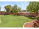 Spacious, green backyard with mature trees, landscaping, and a wheelbarrow at 5721 Awakening St, North Las Vegas, NV 89081