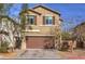 Two-story house with brown garage door and landscaping at 6482 Twin Harbors Ct, Las Vegas, NV 89141