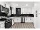 Modern kitchen with white cabinets, black herringbone backsplash, and stainless steel appliances at 724 6Th St, Boulder City, NV 89005