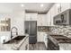 Modern kitchen with stainless steel appliances, white cabinets, and granite countertops at 10318 Glimmering Star Dr, Las Vegas, NV 89178