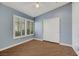 Bedroom with blue walls, wood-look flooring, large window with plantation shutters, and closet at 2727 Coventry Green Ave, Henderson, NV 89074