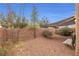 Spacious fenced backyard with desert landscaping, a patio, and a striped awning at 499 Warminster Ave, Las Vegas, NV 89178