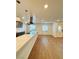 Modern kitchen and dining area with light wood-look flooring, white countertops, and stainless steel appliances at 5409 Holmby Ave, Las Vegas, NV 89146