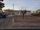 Single-story home with carport, fenced yard, and desert landscaping at sunset at 158 Copper St, Henderson, NV 89015