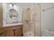 Clean bathroom with a glass shower, round mirror, and wooden vanity at 2590 W Betty Ave, Pahrump, NV 89060