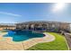 Exterior view of the home with a pool, grassy area, and stone accents at 2590 W Betty Ave, Pahrump, NV 89060