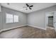 Spacious bedroom with wood-look tile flooring, ceiling fan, and large window providing natural light at 2895 Sunlit Glade Ave, Henderson, NV 89074