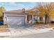 One-story home with a tile roof, attached two-car garage, and red front door at 5372 Polo Grounds St, Las Vegas, NV 89148