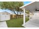 Backyard with covered patio, storage shed, green lawn, and mature trees at 932 Sweeping Vine Ave, Las Vegas, NV 89183