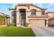 Two-story home with a tiled roof, attached garage, and green lawn at 932 Sweeping Vine Ave, Las Vegas, NV 89183