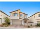 Two-story house with beige exterior, brown roof, and a two-car garage at 23 Papavero Ct, Henderson, NV 89011