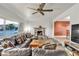 Living room with a leather sectional sofa, fireplace, ceiling fan, and large windows at 260 E Desert Rose Dr, Henderson, NV 89015