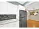 Kitchen with white cabinets, a tile backsplash, and stainless steel refrigerator at 3866 S Torrey Pines Dr, Las Vegas, NV 89103