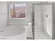 Bathroom boasts a soaking tub, glass-enclosed shower, and window view at 4839 Donna St, North Las Vegas, NV 89081