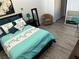 Spacious bedroom with teal bedding and wood-look flooring at 657 Glenwood Ln, Henderson, NV 89002