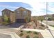 Two-story home with a driveway, attached garage, and desert landscaping at 85 Golden Aria Ave, Henderson, NV 89011