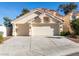 Two-story house with a beige exterior, two-car garage, and landscaping at 1100 Maserati Dr, Las Vegas, NV 89117