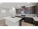 Kitchen with white countertops, an island, dark cabinets, and stainless steel appliances at 11820 Pelican Butte Ave, Las Vegas, NV 89138