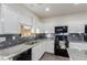 Modern kitchen featuring white cabinetry, black appliances, and a stylish backsplash at 361 Andy Wheeler Dr, Henderson, NV 89011