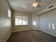 Cozy bedroom with carpeted floors, a ceiling fan, and a large window at 7151 S Durango Dr # 214, Las Vegas, NV 89113