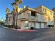 Exterior view of a three-story condo building with attached garages and palm trees at 7151 S Durango Dr # 214, Las Vegas, NV 89113