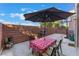 A small backyard with a patio table with an umbrella, grill, and basketball hoop at 9120 Glennon Ave, Las Vegas, NV 89148