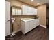 Laundry room with white cabinets, dark wood floors, and a utility sink at 1608 Joshua Tree Ct, Las Vegas, NV 89108