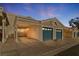 Two-car garage with blue doors and a covered carport at dusk at 2231 Camel Mesa Dr, Laughlin, NV 89029