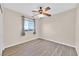 Well-lit bedroom with wood-look floors, ceiling fan, and window with distant view at 4038 Sparrow Rock St, Las Vegas, NV 89129