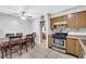 Kitchen with wood cabinets, a gas stove, a dining table, and a ceiling fan at 6109 Empire Cir, Las Vegas, NV 89107