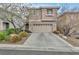 Two-story house with beige exterior, attached garage, and landscaping at 10445 Trout River St, Las Vegas, NV 89178