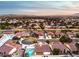 Aerial view of a house with a pool, showcasing a beautiful sunset and distant city views at 5604 Island Breeze Ct, Las Vegas, NV 89130