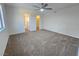 Spacious carpeted bedroom with ceiling fan and mirrored closet doors at 1636 Lorna Dr, Henderson, NV 89011