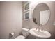 Stylish powder room with pedestal sink and oval mirror at 23 Cresta Villa Ct, Henderson, NV 89011