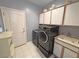 Well-lit laundry room with washer, dryer, and cabinets at 720 Florida St, Pahrump, NV 89048