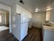 Galley kitchen with white cabinets and wood-look floors at 120 Maple St, Henderson, NV 89015