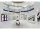 Elegant two-story entryway with a grand staircase and marble table at 1801 S Cimarron Rd, Las Vegas, NV 89117