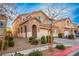 Two-story house with tan exterior, arched entryway, and landscaping at 221 Gemstone Hill Ave, North Las Vegas, NV 89031