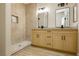 Modern bathroom with double sinks, walk-in shower, and light wood cabinets at 4810 Grey Wolf Ln # 104, Las Vegas, NV 89149