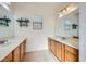 Double vanity bathroom with wood cabinets and a large mirror at 5704 Flying Birdie Ave, Las Vegas, NV 89122