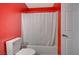 Bathroom with red walls, white toilet and bathtub at 2986 Juniper Hills Blvd # 204, Las Vegas, NV 89142