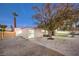 Backyard with gravel, trees, and a modern fence at 3240 Medicine Man Way, Las Vegas, NV 89169