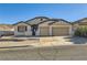 Beige house with two-car garage and landscaped yard at 60 Vista Del Mar St, Henderson, NV 89012