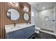 Modern bathroom with blue vanity, marble shower, and circular mirrors at 7849 Montour Falls St, Las Vegas, NV 89149