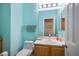 Light teal bathroom with wood vanity and updated fixtures at 817 E La Madre Way, North Las Vegas, NV 89081