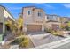 Two-story house with tan exterior, brown garage door, and landscaped front yard at 8574 Felker St, Las Vegas, NV 89166