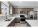 Modern kitchen with double sink, stainless steel appliances, and white countertops at 8574 Felker St, Las Vegas, NV 89166